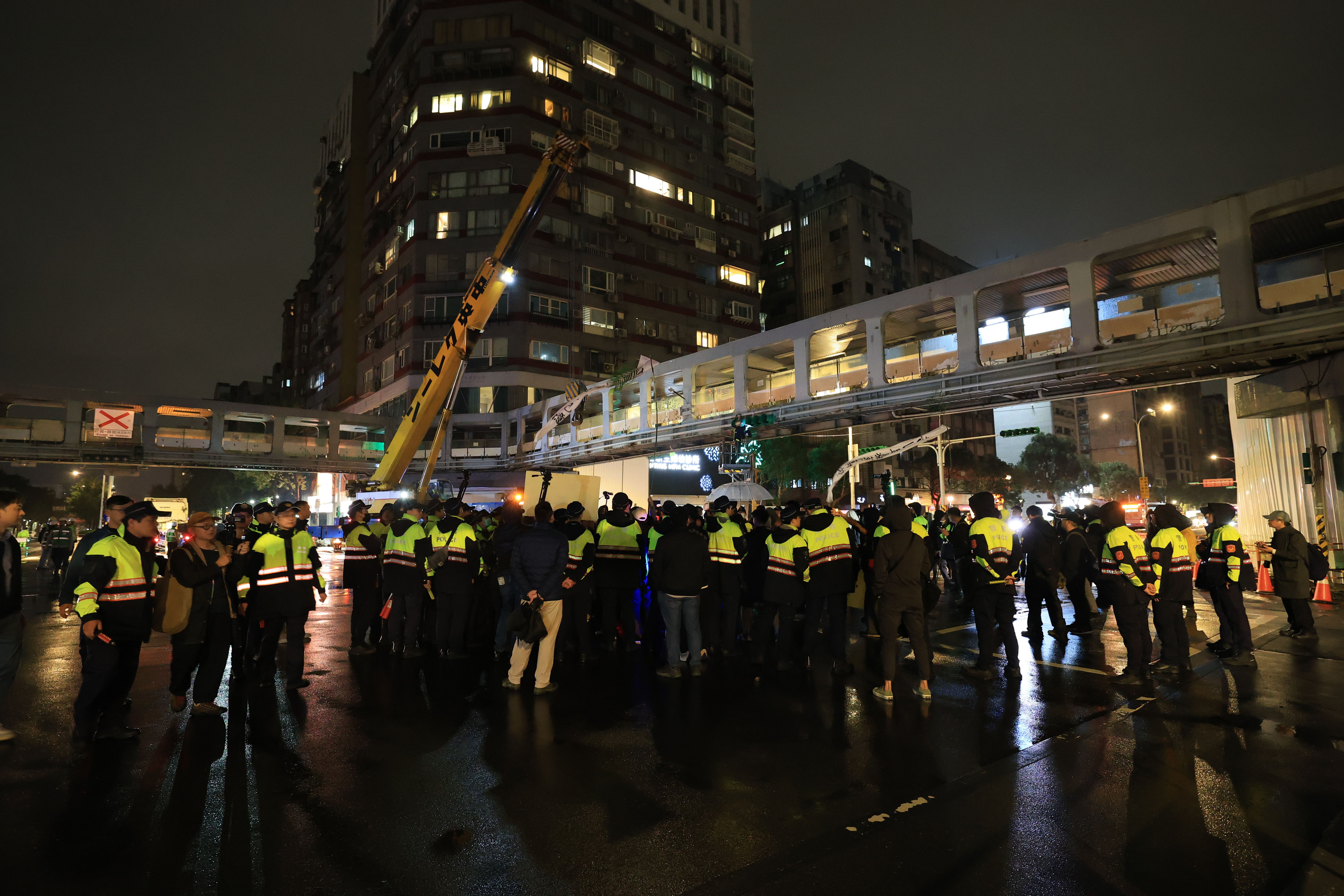 拆除過程中，民團聚集橋下抗議，阻止施工，市府單位也派出大量警力，維護現場施工能順利進行。　圖／李宸緯攝