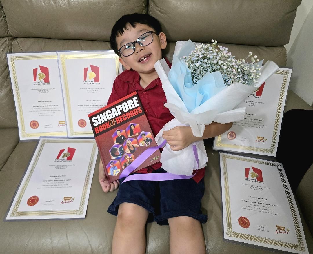 7歲的關穎恩榮獲多項學術獎項肯定，手捧鮮花開心合影，身旁滿滿的文憑見證他非凡的歷程。　圖／鄭婕儀提供