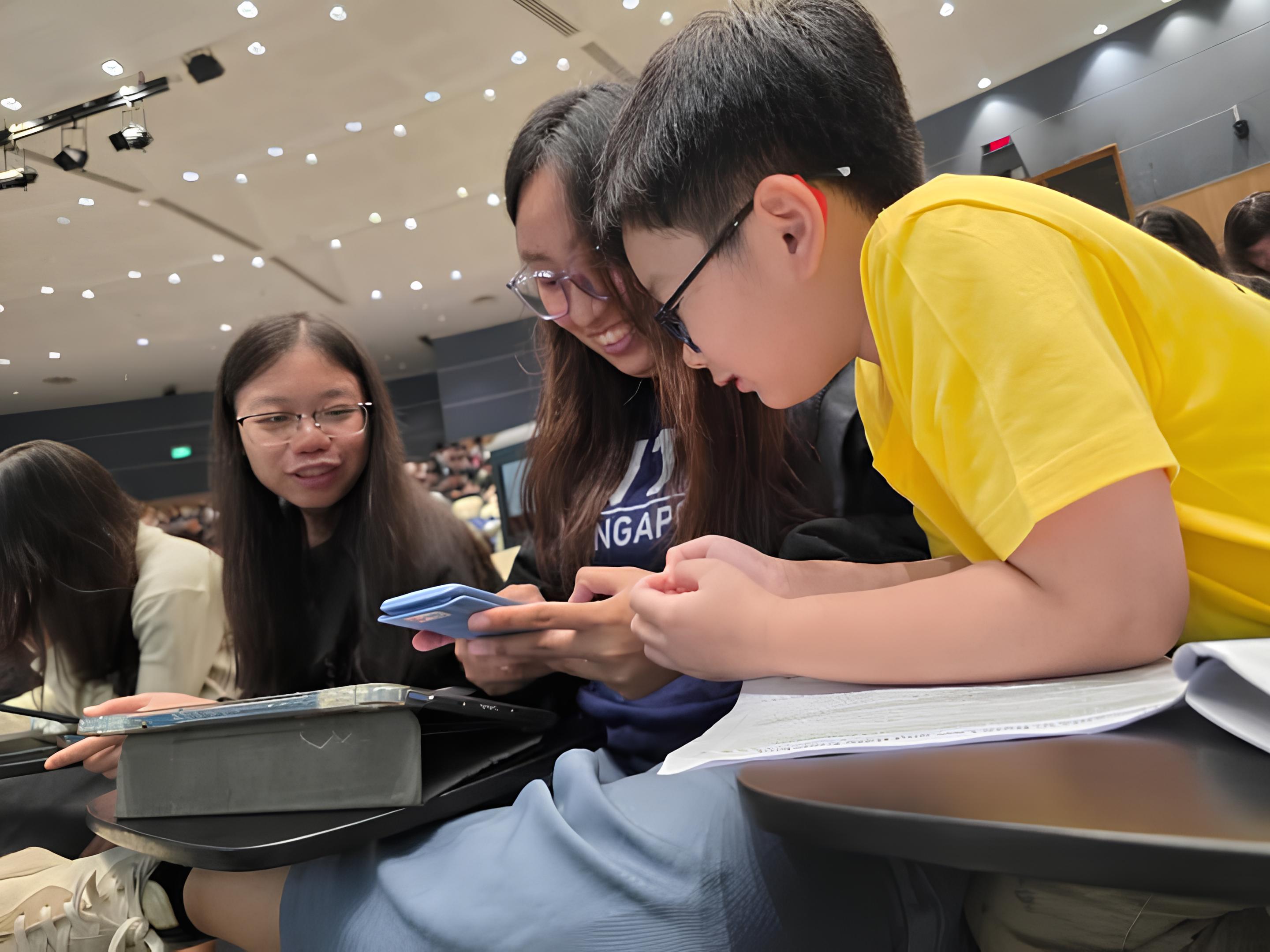 課堂休息間隙，關穎恩與大學生討論課業內容，交流彼此的想法與筆記，展現跨年齡學習的環境。　圖／鄭婕儀提供