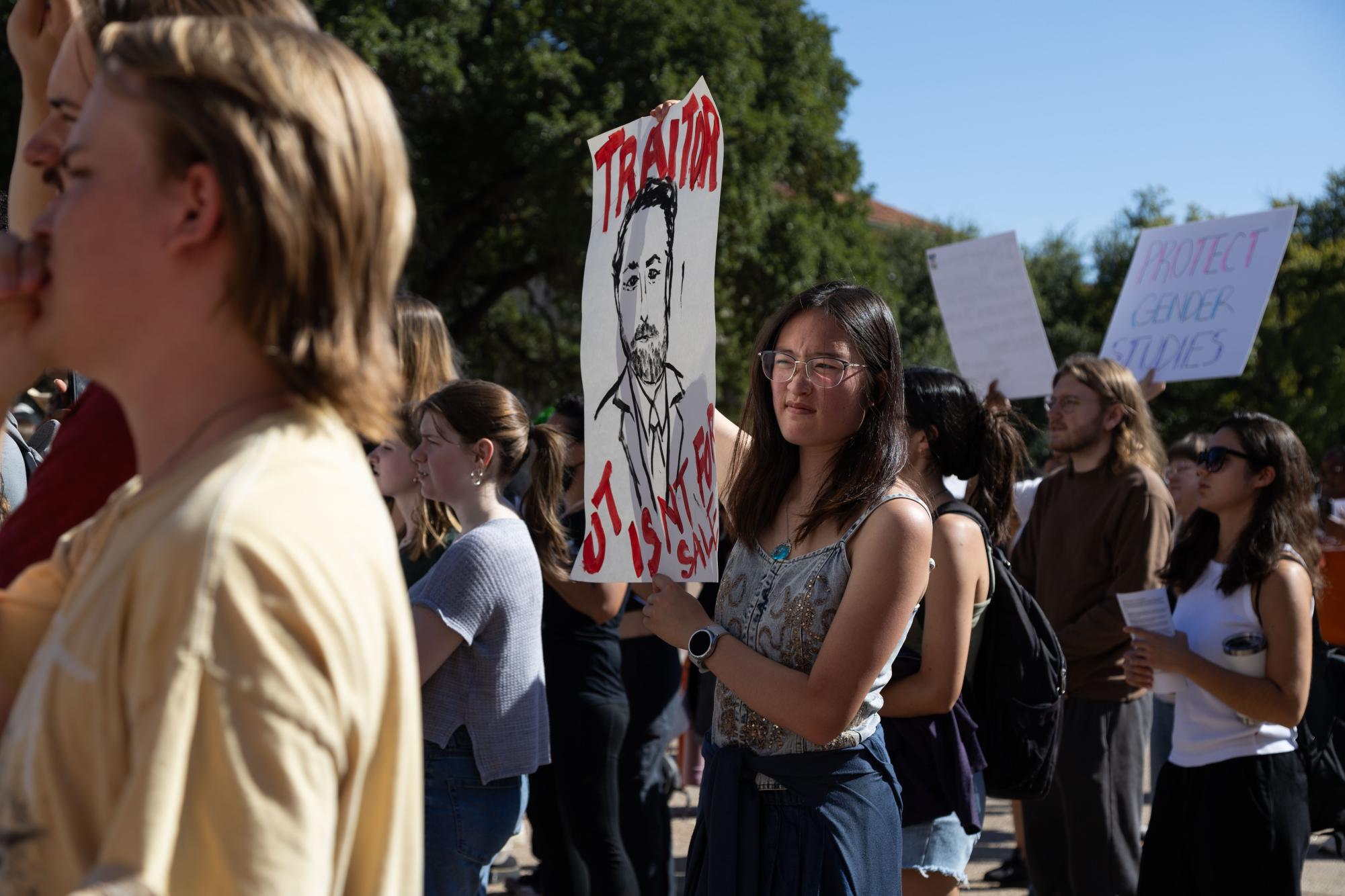 學生高舉看板譴責校方高層為叛徒，批評學校以學生權益換取政府補助。　圖／Naina Srivastava提供