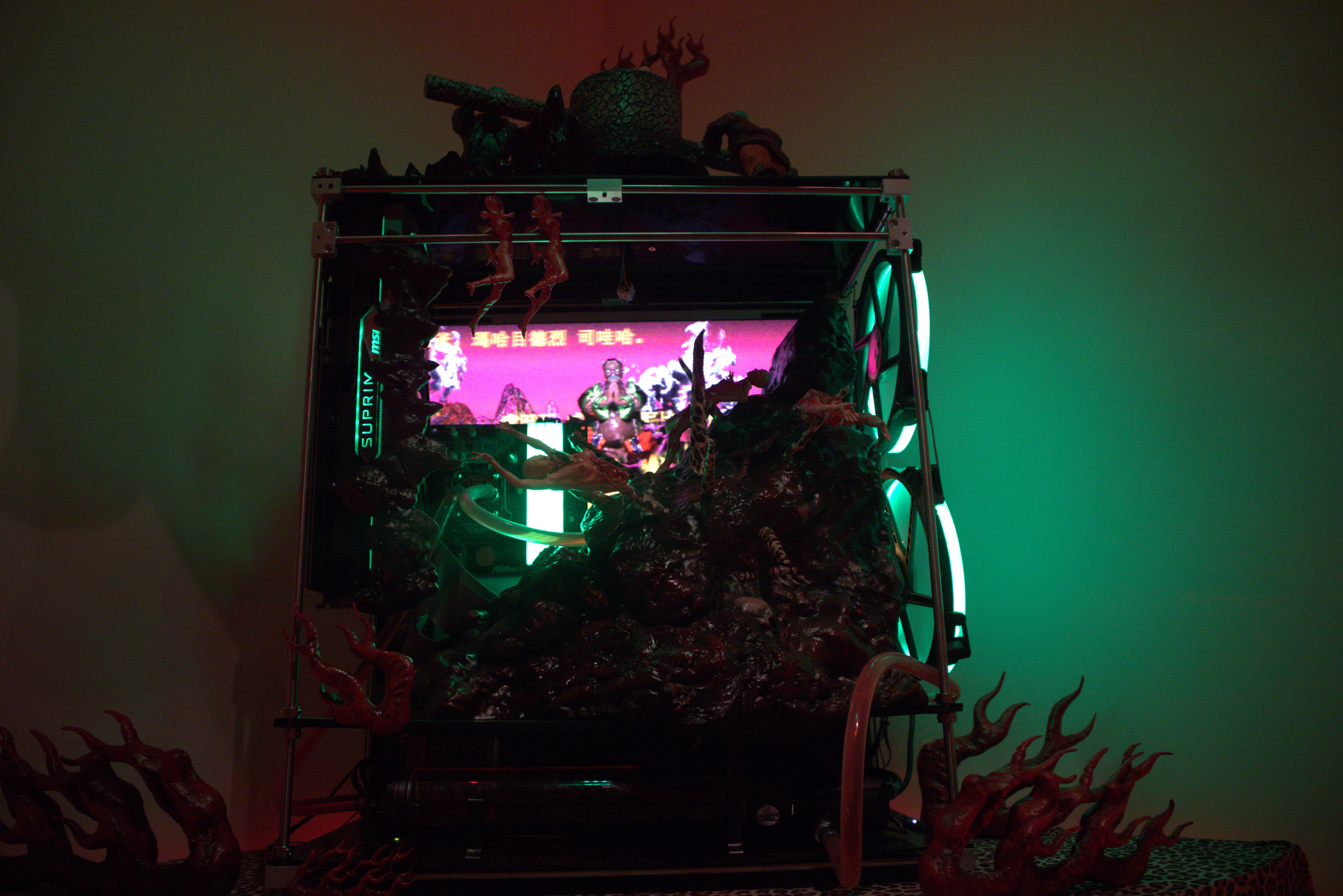 〈地獄電腦〉後方的螢幕播放著《佛頂尊勝陀羅尼經》，為作品增添了超度苦難的宗教性思考。　圖／邱柏翔攝