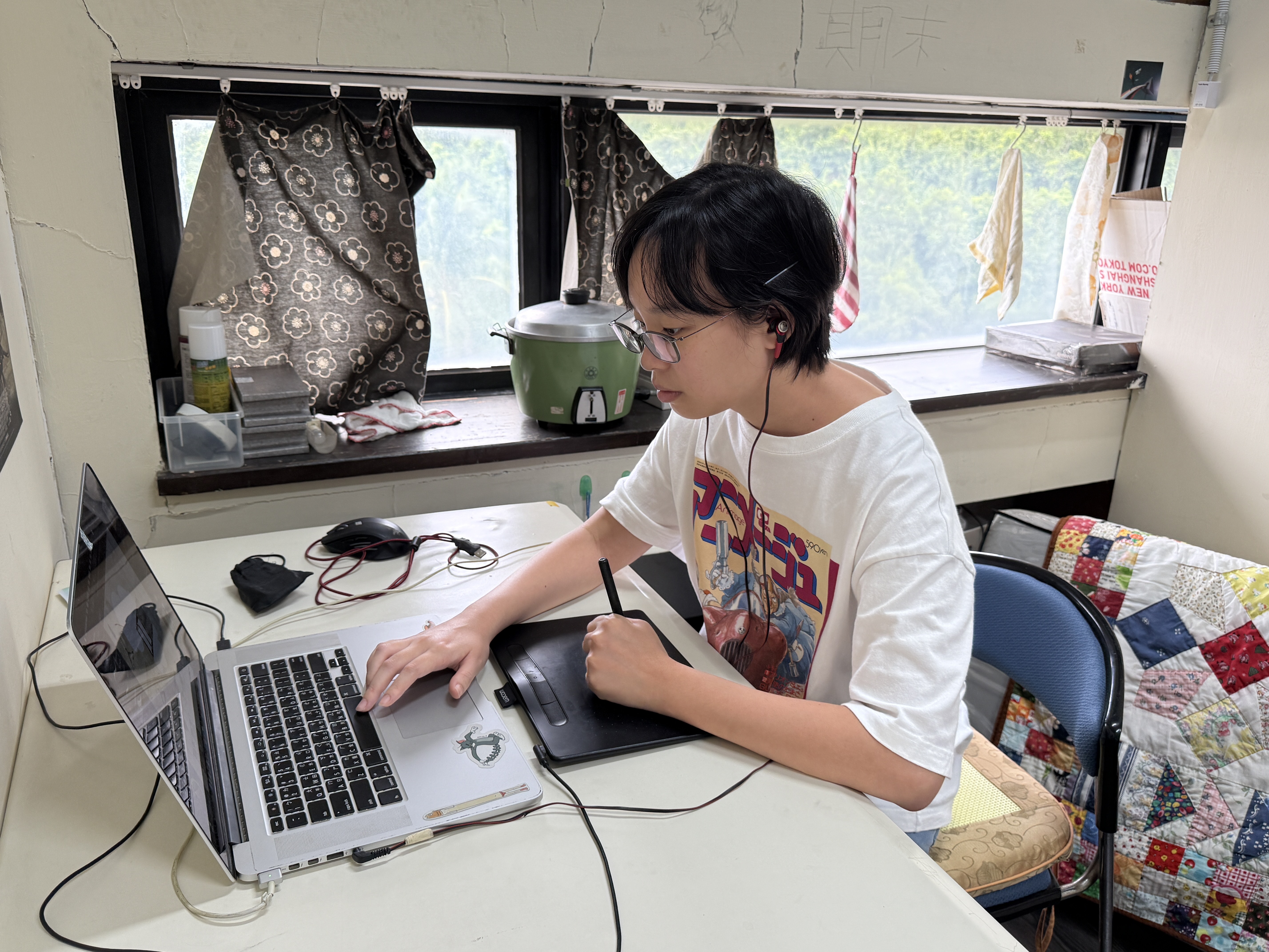 《兔子巷968號》的發想來自支持吳家昕創作的家人，而他身後是母親縫製的拼布被子。　圖／吳家昕提供