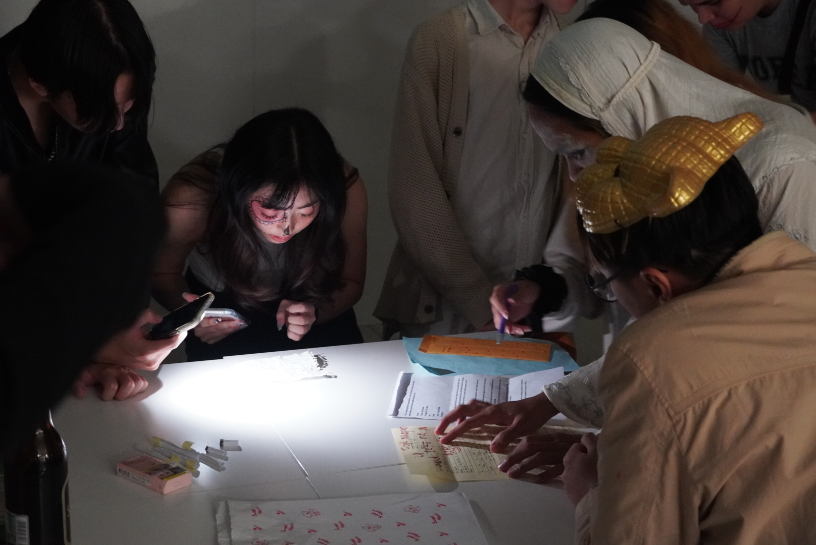 學生們分不同家族參與實境遊戲，並拍下不同道具仔細研究，共同推理案件劇情。　圖／李若水攝