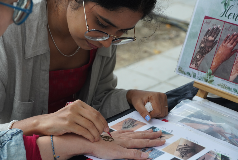 新住民攤商為民眾繪製印度傳統海娜紋身，展現跨國交流。　圖／劉倚瑄攝