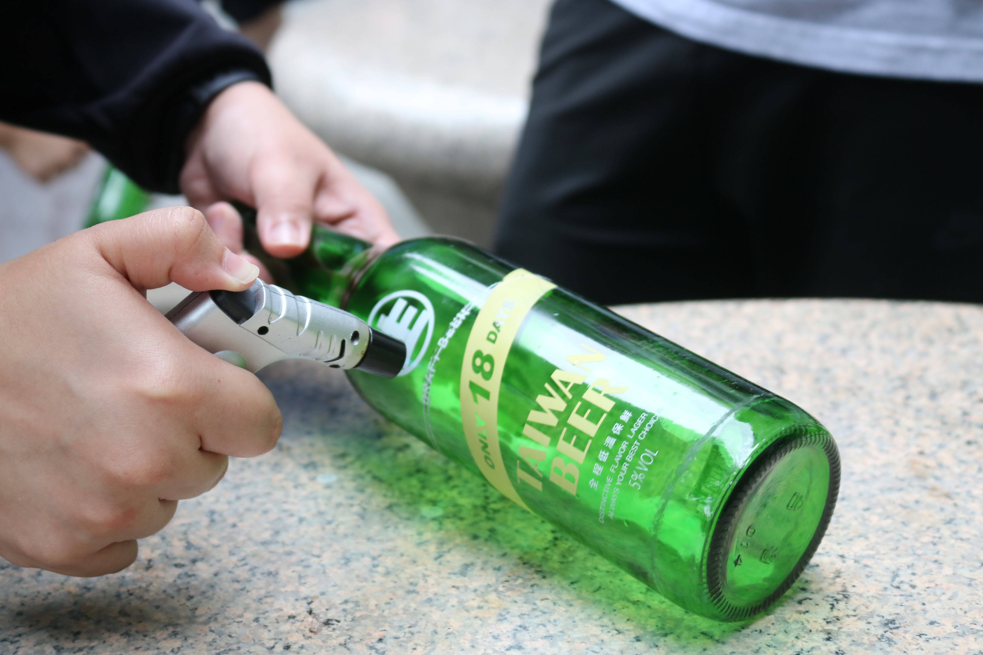 燒製過程玻璃會發出聲響，指導老師提醒參加者切忌因害怕而鬆手，否則會摔碎瓶子。　圖／丘羨陶攝