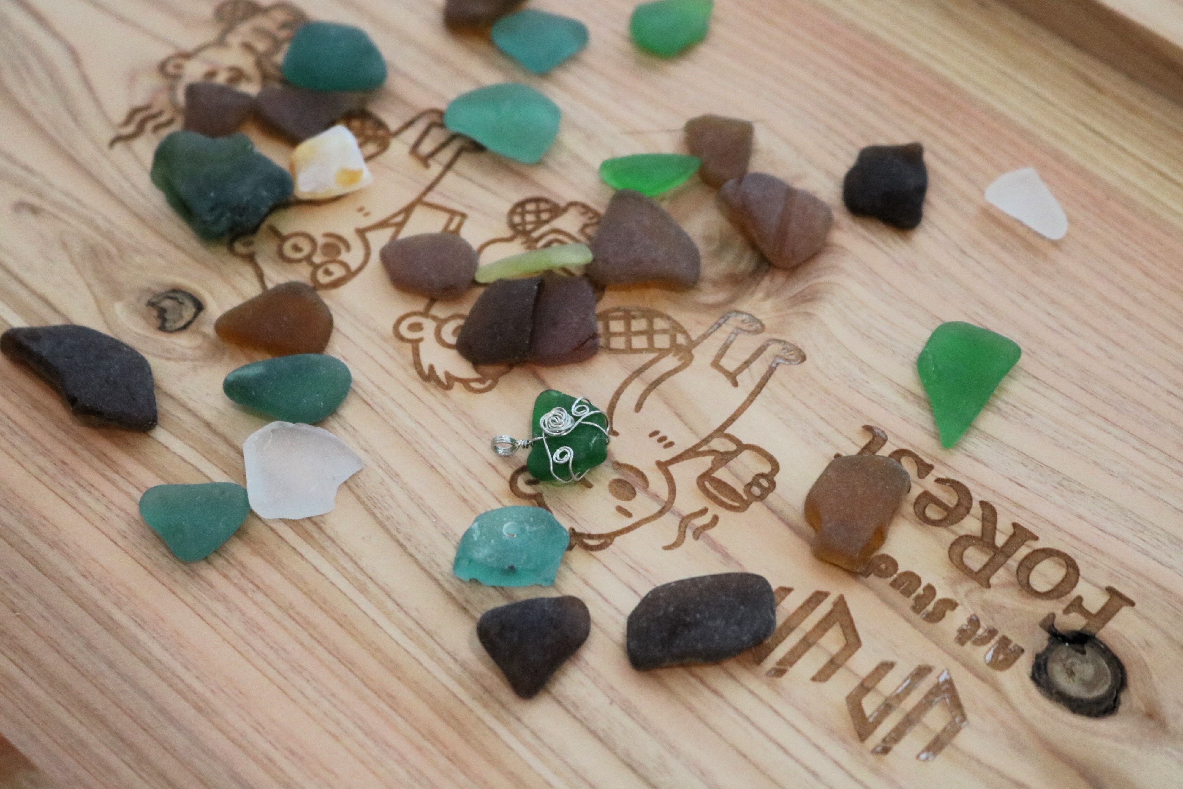 經過海浪和沙石打磨的玻璃碎片表面光滑、各有不同形狀，可以直接加工成飾品。　圖／丘羨陶攝