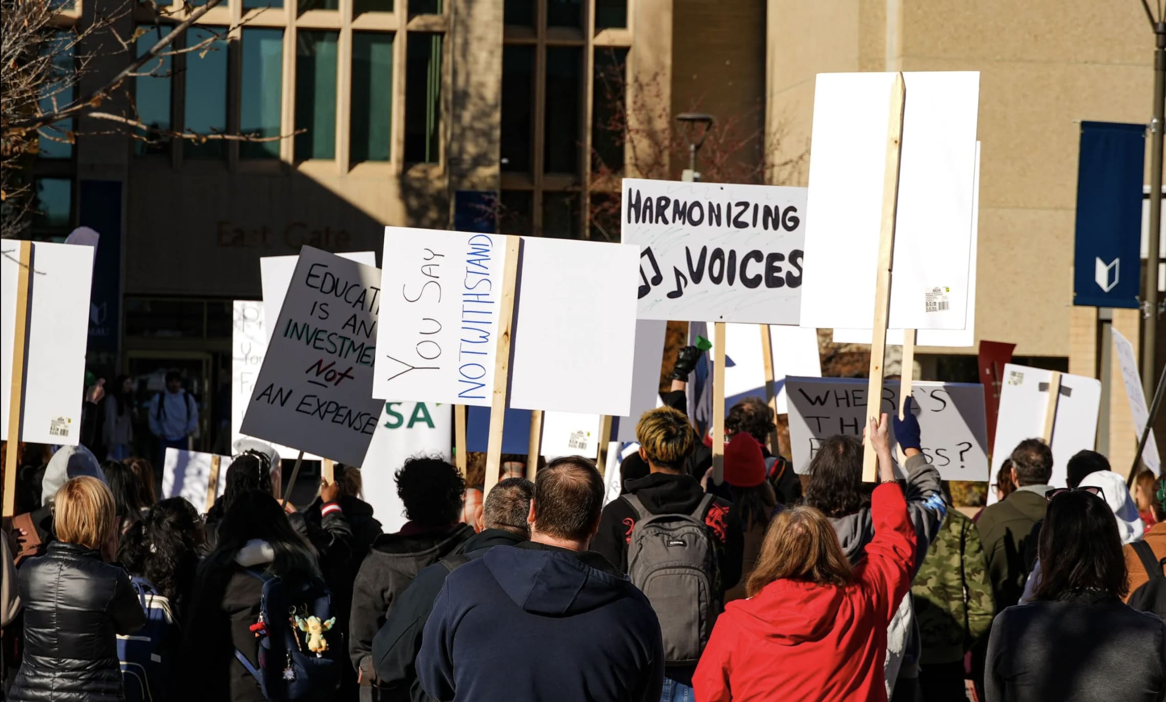 皇大教職員工與學生於校園內舉牌，聲援亞伯達省的教職人員。　圖／法蘭奇提供