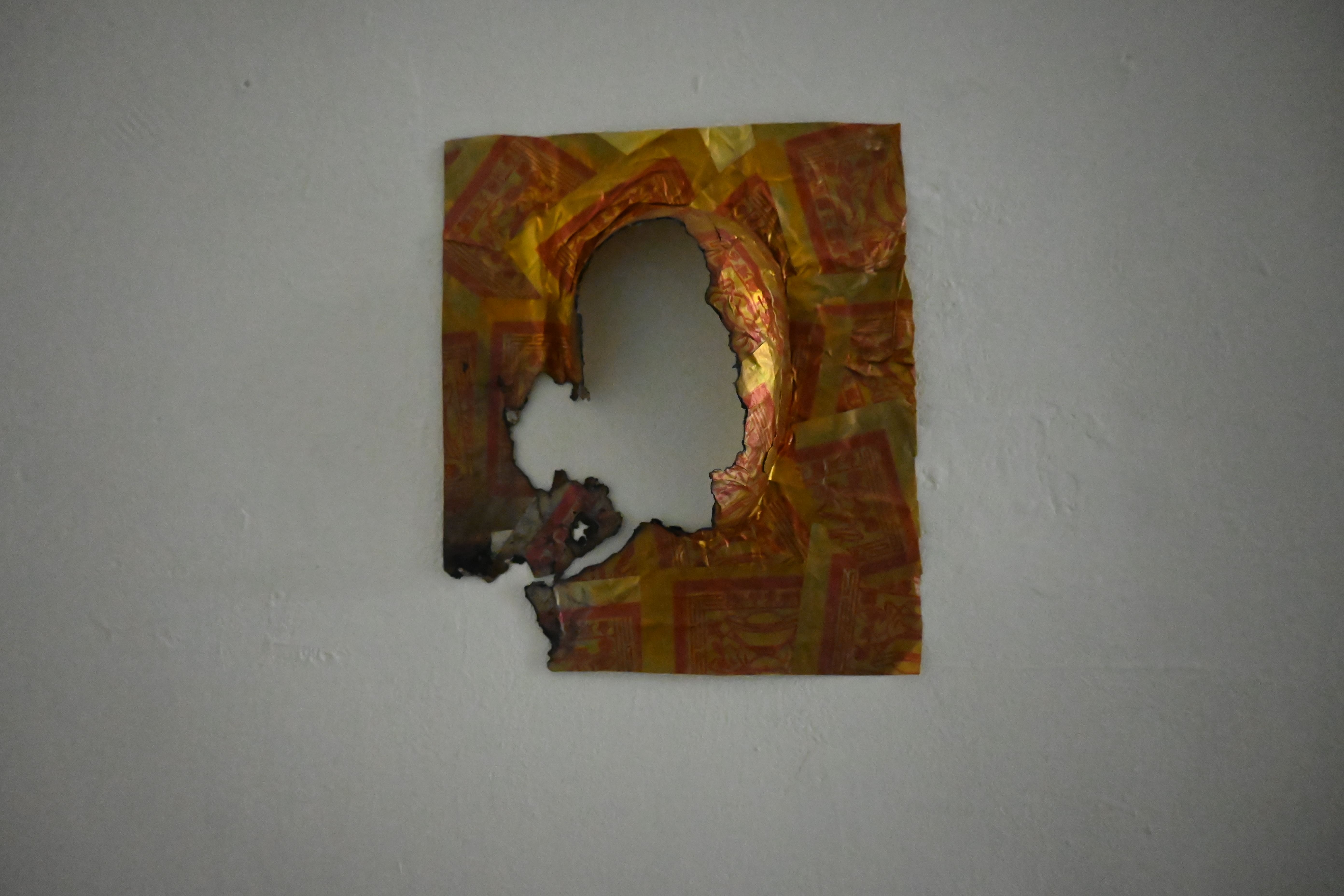 〈新生〉從作品的左下角燃燒，透過焚燒這具金紙面具，象徵人經歷的毀滅與失落。　圖／林庭如攝