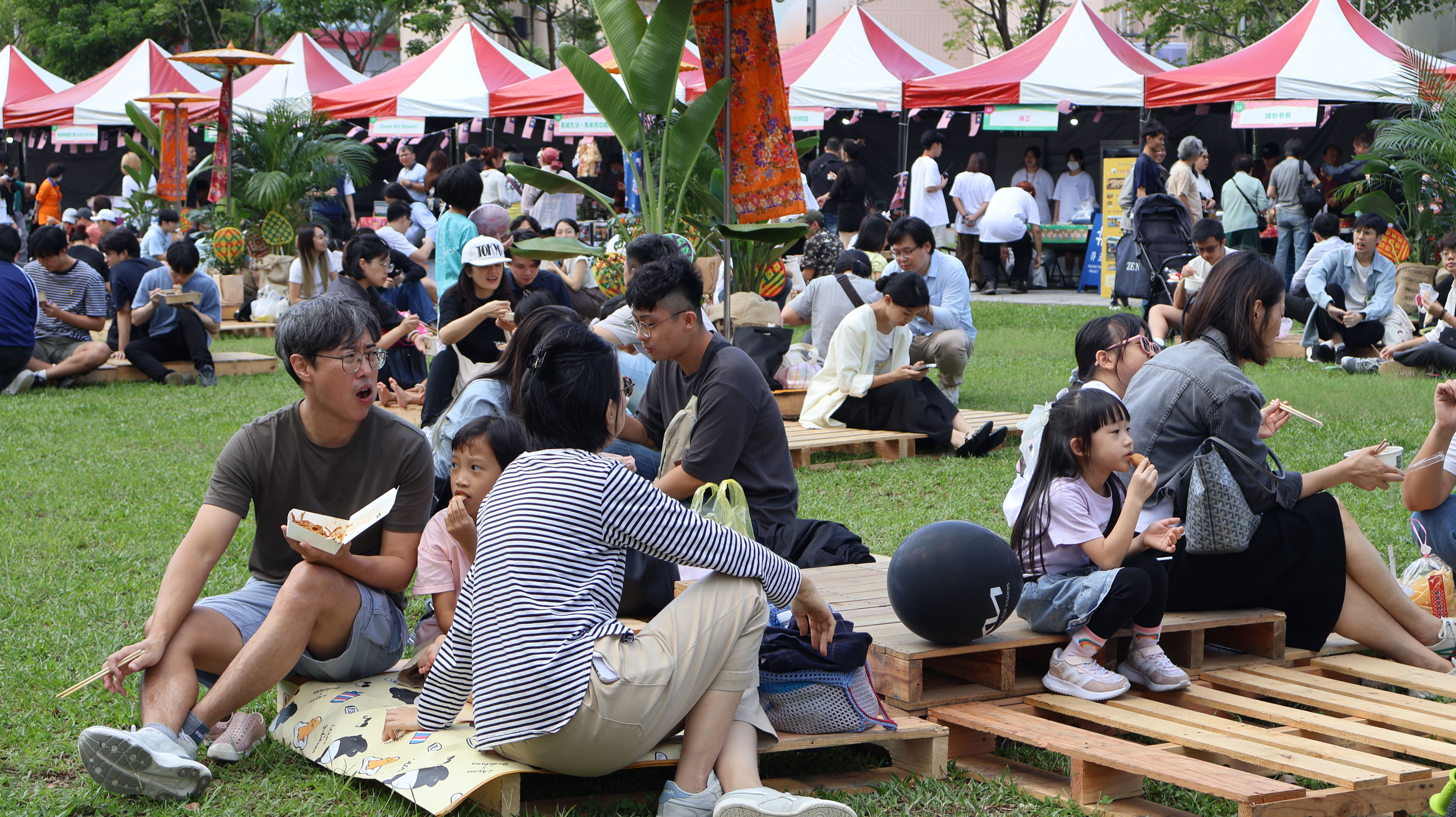 馬來西亞文化日現場，民眾蓆地而坐品嘗各式佳餚，感受輕鬆自在的文化日氛圍。　圖／顏貝恩攝