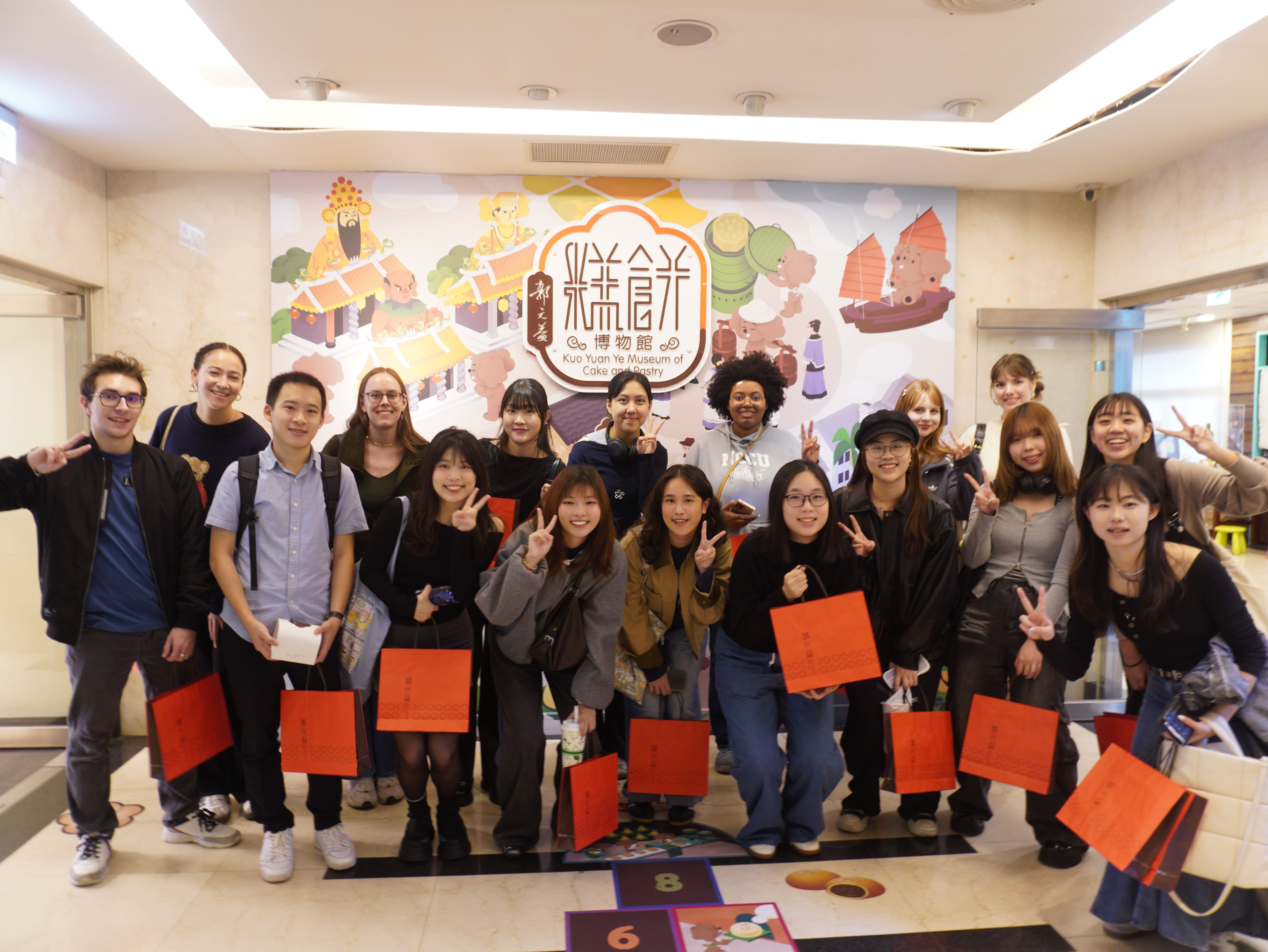 台灣與外籍學生在活動後手持鳳梨酥齊聚合影，分享彼此交流的成果。　圖／黃千艾攝