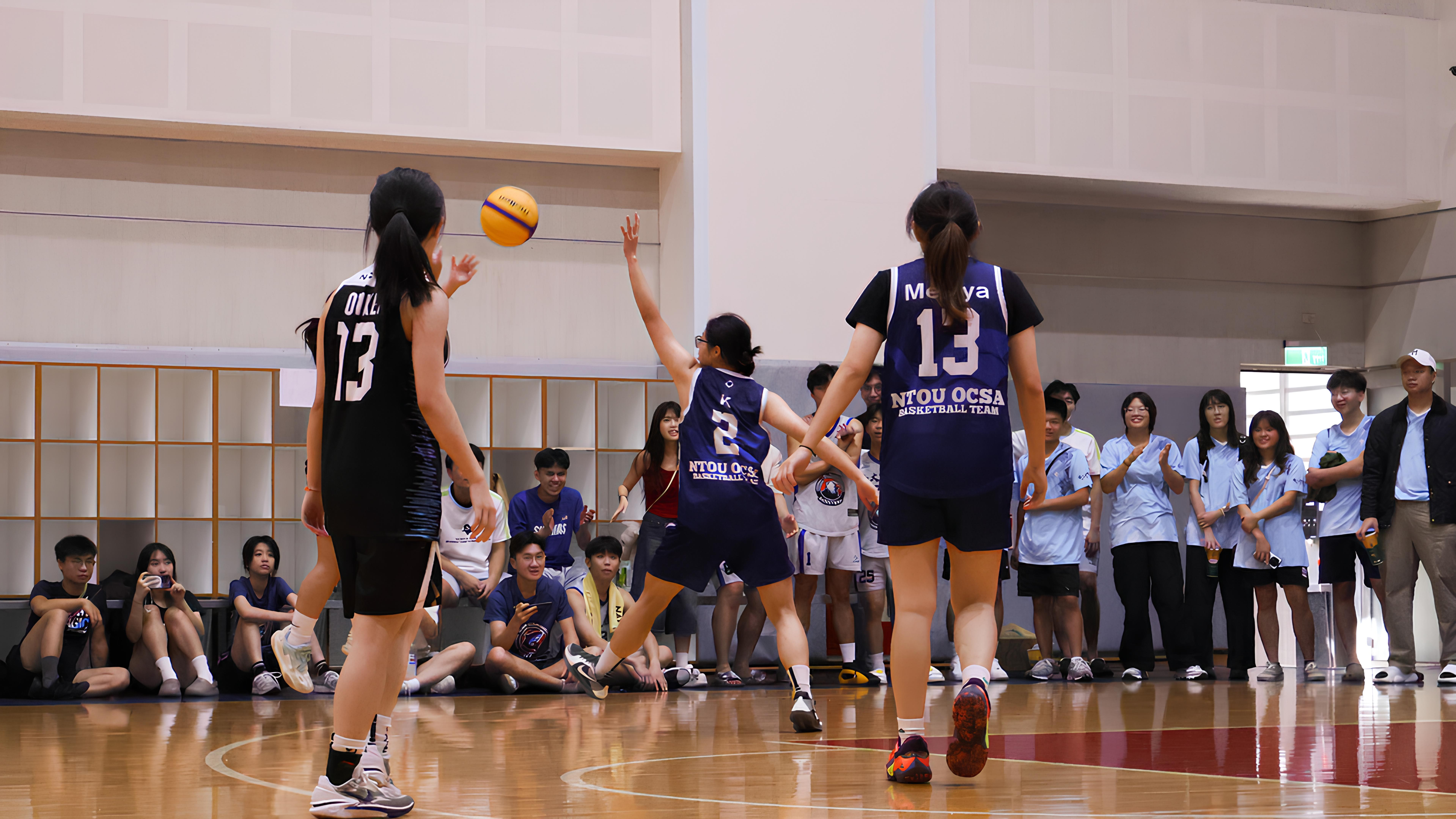 女子籃球決賽戰況激烈，選手迅速回防搶球，場邊觀眾全神貫注的關注比賽動向。　圖／顏貝恩攝