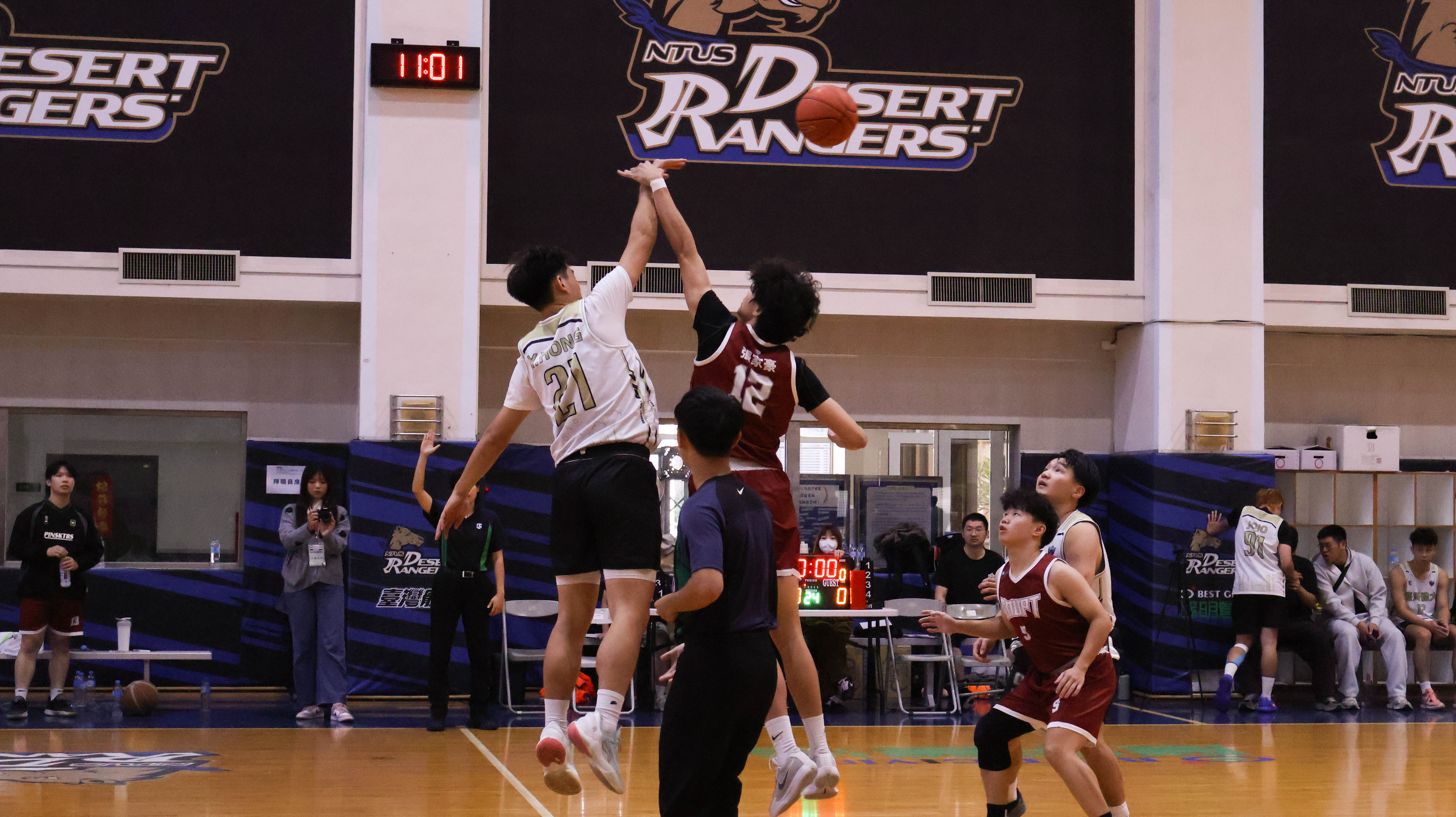 籃球比賽以跳球開局，雙方選手全力爭奪球權，氣氛緊張熱烈。　圖／顏貝恩攝