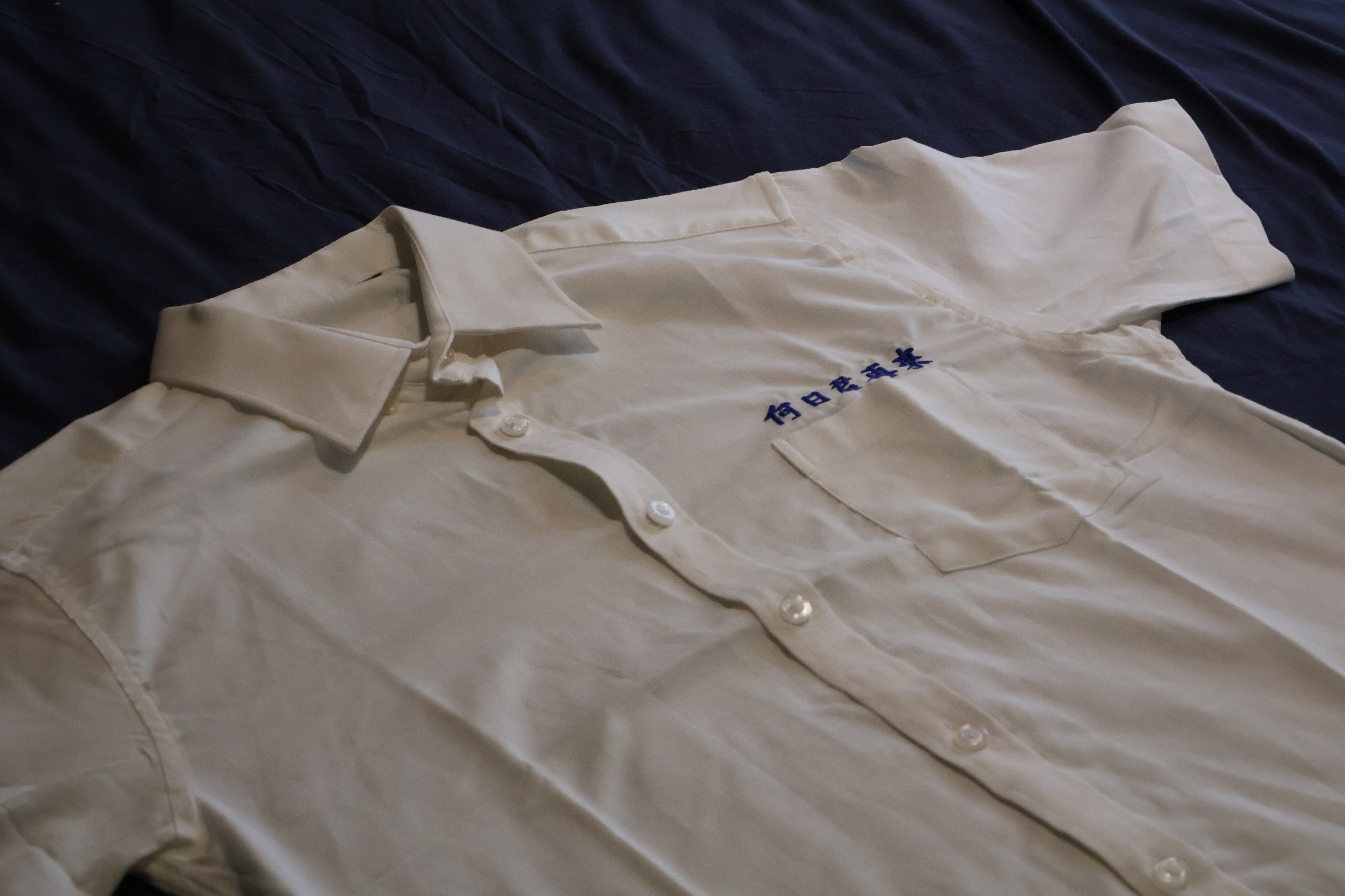 盧國聰指出，衣物繡上姓名象徵身份確認，而展區中襯衫所繡的文字，彷彿訴說當事人在思念中逐漸迷失自我。　圖／陳雙攝 